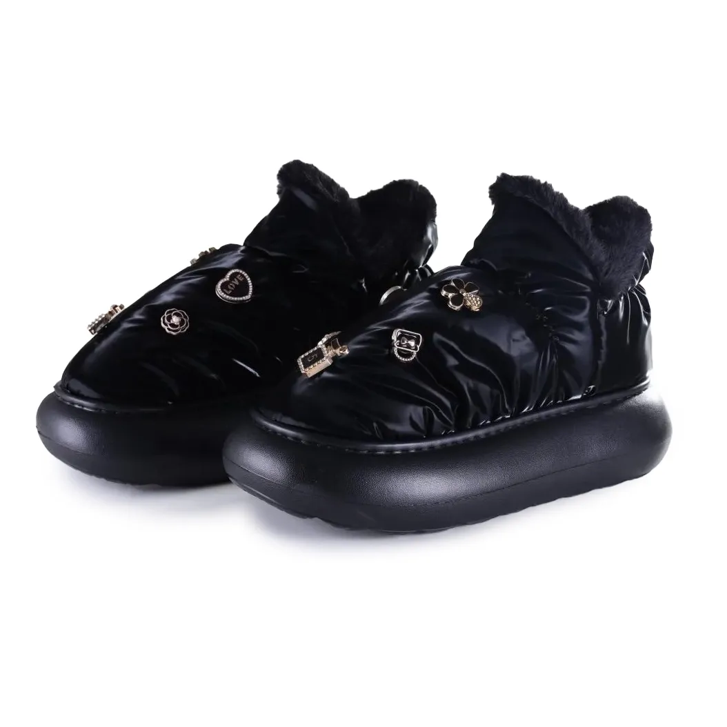 Par de pantufas Flowfa pretas em perspectiva três-quartos destacando textura e solado plataforma.